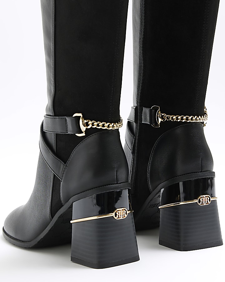 Black heeled high leg boots