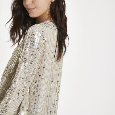 Goudkleurige top met pailletten en lange mouwen