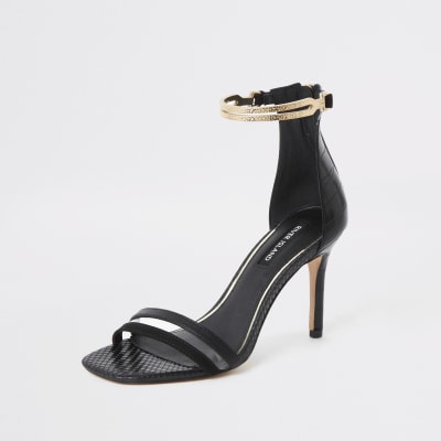 Sandales noires à talons hauts et bride dorée à la cheville