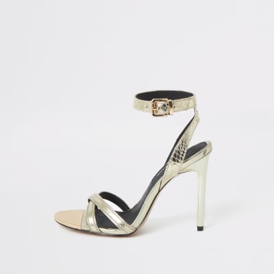 Goldene Schuhe mit Skinny-Absatz