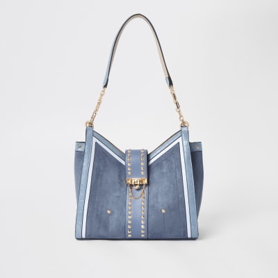 Blaue, nietenverzierte Beuteltasche