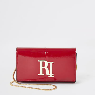 Rode lakleren onderarmclutch met RI-logo