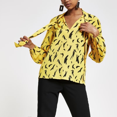 Gele blouse met print en lange mouwen en strik bij de hals