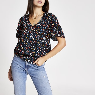 Zwarte shelltop met korte mouwen met ruches en bloemprint