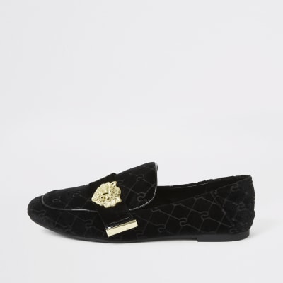 Zwarte fluwelen loafer met leeuw in reliëf en RI-logo