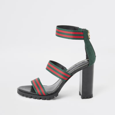 Grüne Absatzsandale mit Streifen und dreifachen Riemchen.