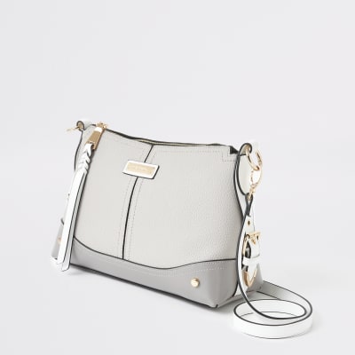 Grijze crossbodytas met gespen aan de zijkant