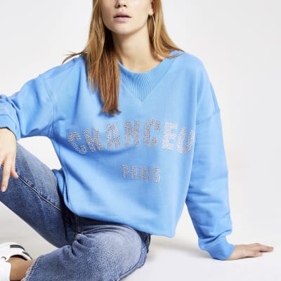 Blaues Sweatshirt mit „Chanceux“-Strassapplikation