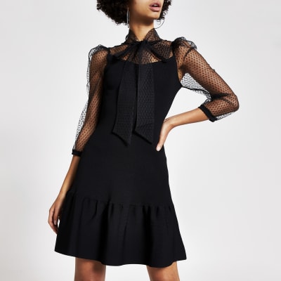 Schwarzes Kleid  mit gepunktetem Netzstoff und Bindeschleife am Kragen