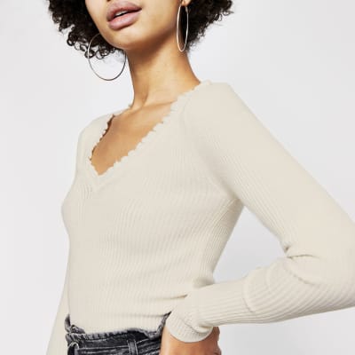 Cremefarbener Strickpullover mit Rüschen und V-Ausschnitt im Rippenstrick