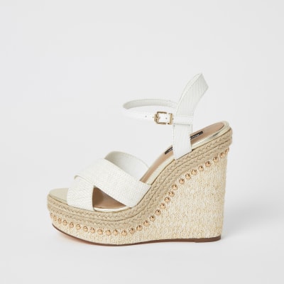 Sandales blanches avec lanières croisées cloutées et talon compensé 