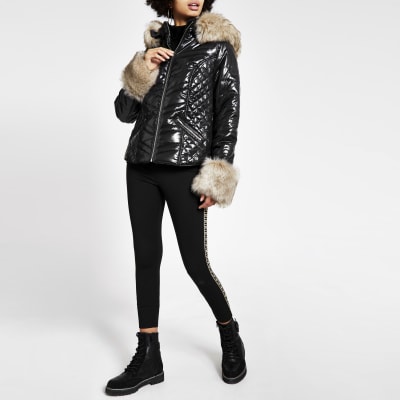 Veste matelassée noire ultra brillante avec manchettes en fausse fourrure