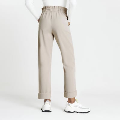Beige pleated peg leg trousers
