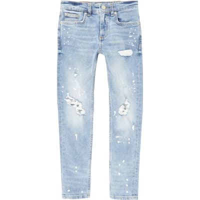 Boys blue ripped paint splat skinny jeans | River Island