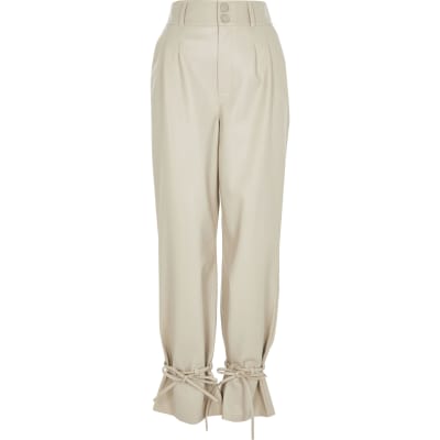 Cream faux leather tie bottom trousers