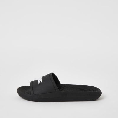 Lacoste black brand embossed sliders | River Island