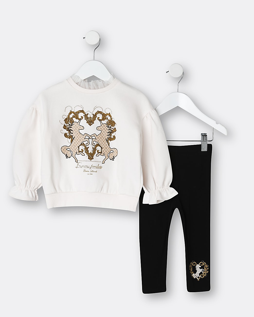 white jumper with two unicorns in gold and a pair of black leggings with the same unicorn Moffit 