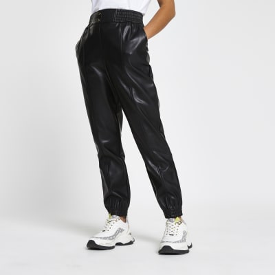 Petite black faux leather slim leg joggers | River Island