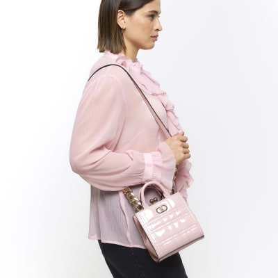 Pink quilted clip top cross body bag River Island