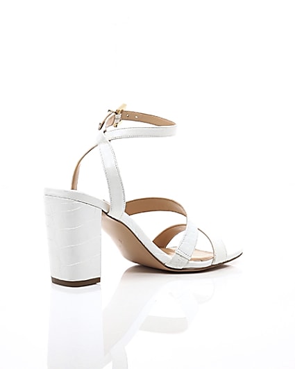360 degree animation of product White asymmetric strappy block heel sandals frame-12