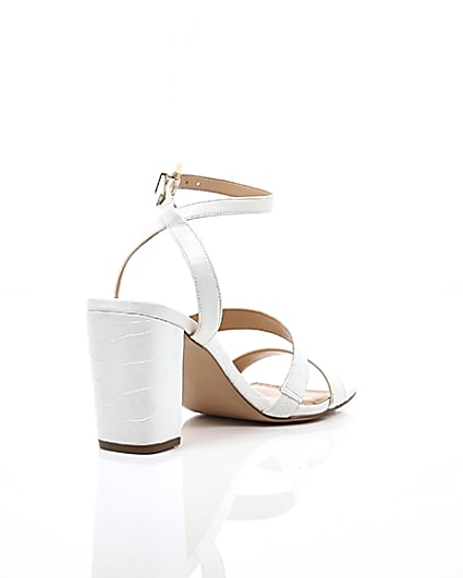 360 degree animation of product White asymmetric strappy block heel sandals frame-13