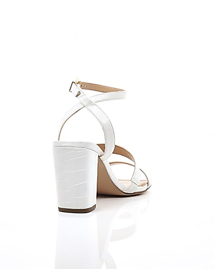 360 degree animation of product White asymmetric strappy block heel sandals frame-14