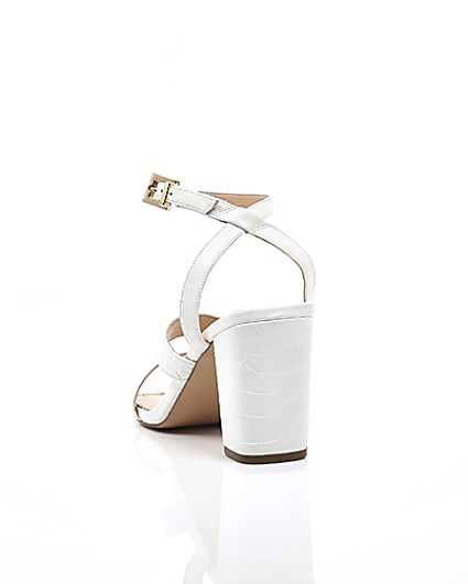 360 degree animation of product White asymmetric strappy block heel sandals frame-17