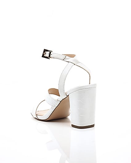360 degree animation of product White asymmetric strappy block heel sandals frame-18