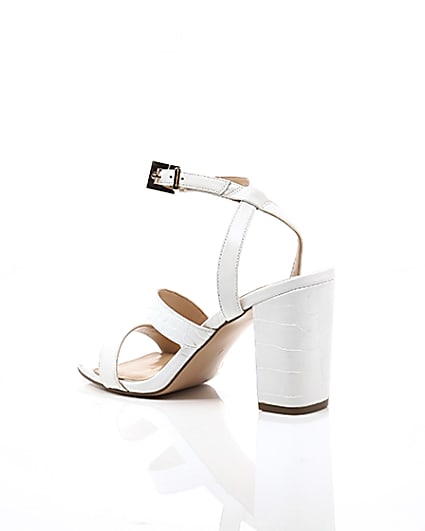 360 degree animation of product White asymmetric strappy block heel sandals frame-19